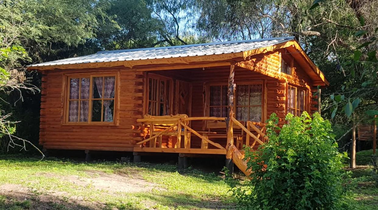 Cabaña de madera del complejo Sueño Dorado entre árboles
